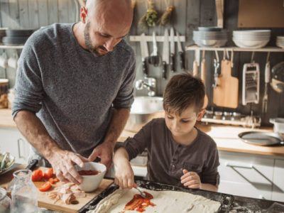 Father with two kids preparing pizza at home