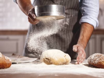 hands of the baker's male knead dough
